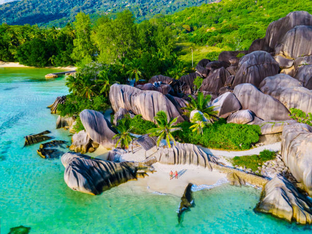 istock Anse Source d'Argent beach, La Digue Island, Seyshelles, Drone aerial view of La Digue Seychelles bird eye view, couple men and woman walking at the beach during sunset at a luxury vacation 1575757893