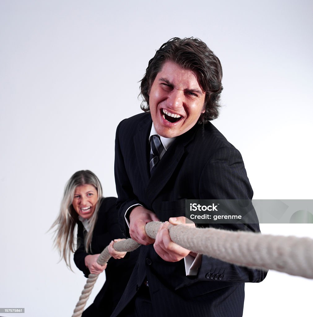 Tug of war Businessman and businesswoman playing tug of War in a office Tug-of-war Stock Photo