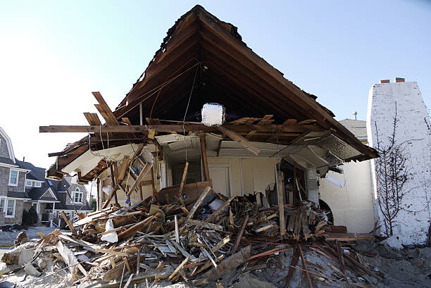 Heavy duty excavator demolishing an old house. Detail on the shingle roof demolish.