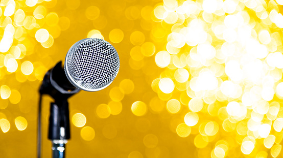 Microphone on shiny golden background.