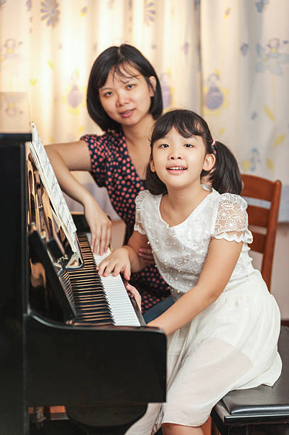 istock Asian girl playing piano 157577045