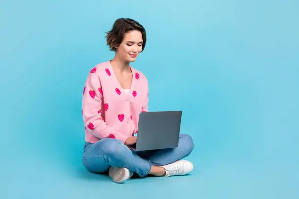 Photo of Full body photo of cute young woman bob brown hair sit floor using new apple macbook comfort workplace isolated over blue color background