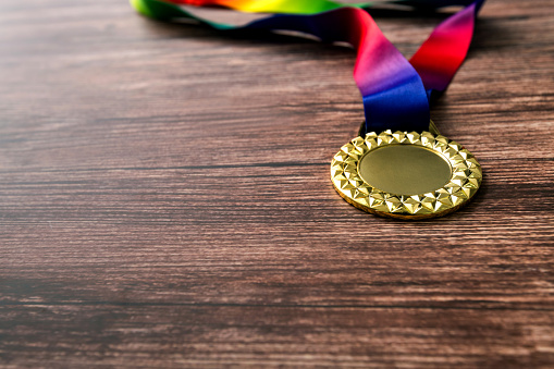 A gold medal on wooden table.