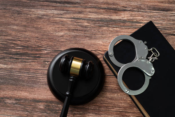 istock Gavel and handcuffs on wooden table 1575772697