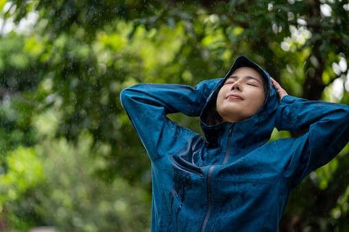 Enjoying the rainy weather. a young woman standing in the rain.