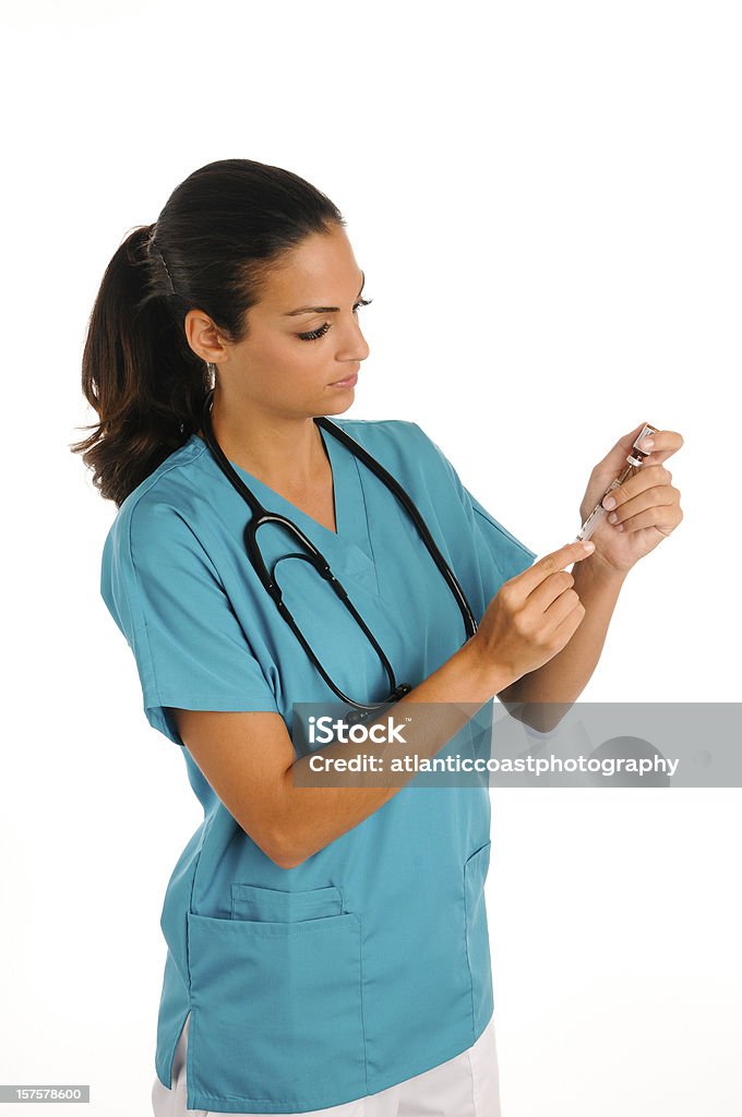 Young nurse giving meds. Young nurse draws medicine into a syringe. 20-24 Years Stock Photo