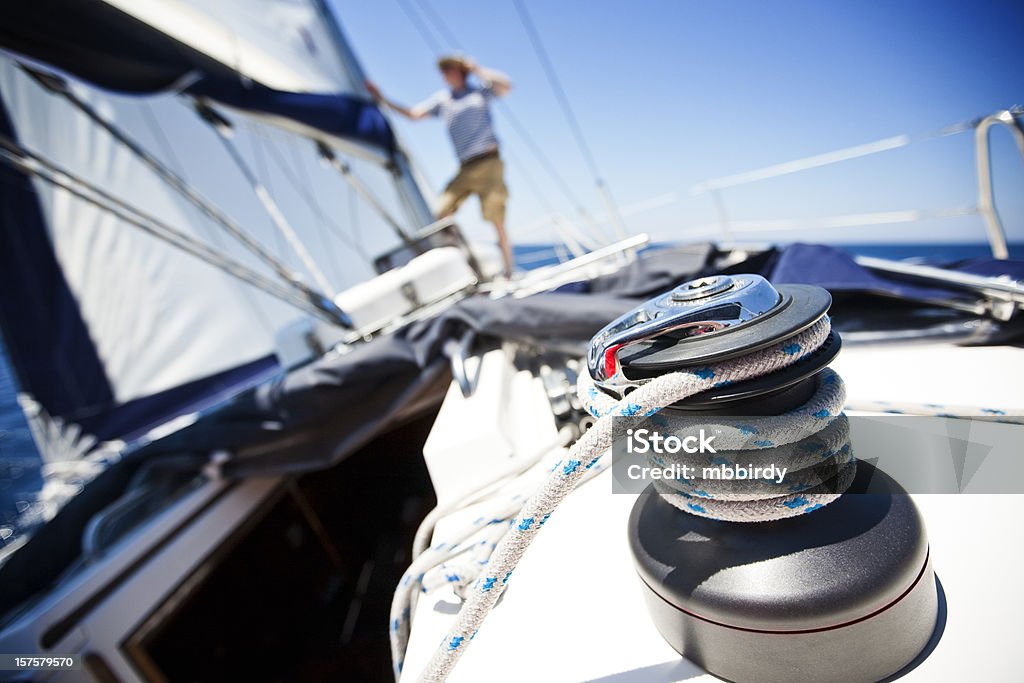 Crew member checking foresail Crew member standing on front part of sailboat and checking foresail. Model released. http://santoriniphoto.com/Template-Sailing.jpg Sailboat Stock Photo