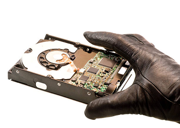 istock stealing data hand in black gloves taking harddrive 157579716