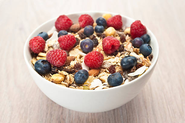 A bowl of breakfast cereals with blueberries and nuts  Muesli Breakfast Cereal with Fresh Fruits granola stock pictures, royalty-free photos & images