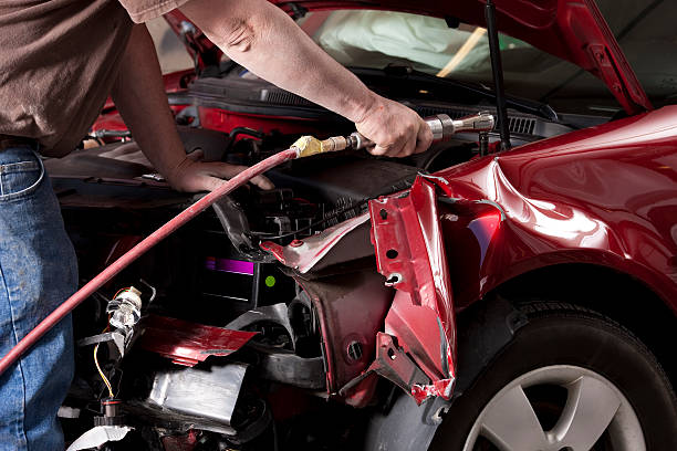 Auto Body Mechanic Disassembling Damaged Vehicle Closeup photo of an auto body mechanic using a compressed air wrench to remove the side fender from a vehicle that was in an auto accident. chassis photos stock pictures, royalty-free photos & images