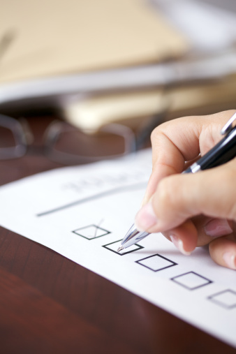 Woman at desk checking off her to do list.