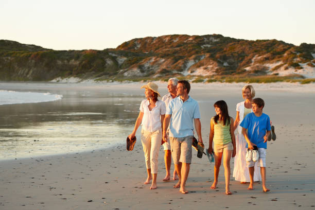 istock Three generational family walking together on beach 157580163