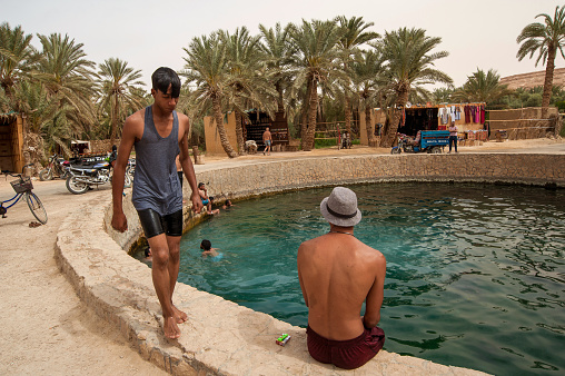 Siwa Oasis, Egypt. April 12th 2018.\nYoung Egyptian men hang out and swim at Cleopatras Pool, Siwa Oasis, Egypt.