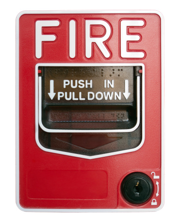 Red fire alarm sounder on a white wall