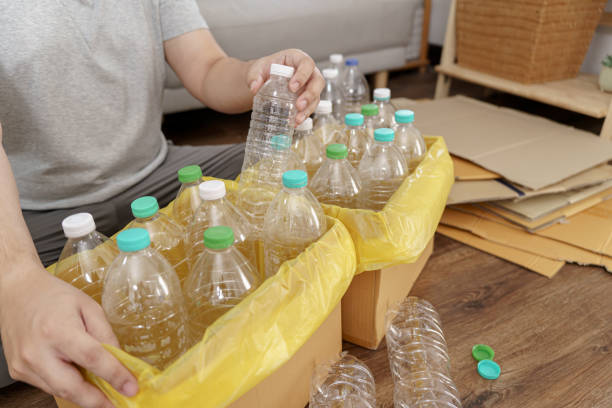 istock Home recycle eco green zero concept Man throwing empty plastic bottle in recycling bin with yellow garbage bags at home 1575804410