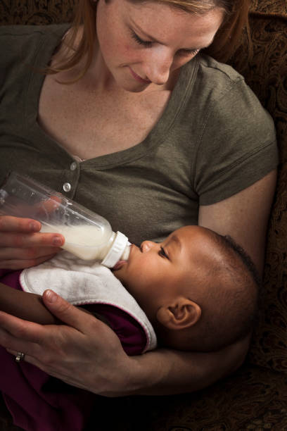 istock mother feeding adopted baby daughter 157580492