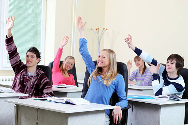 étudiants lever les mains dans une salle de classe. - studygroup photos et images de collection