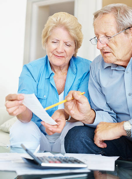 istock Old couple calculating their monthly expenses at home 157580909