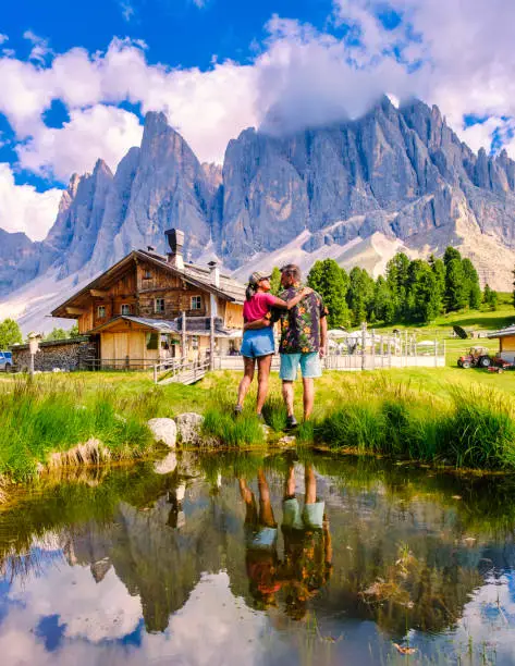Couple men and women at Geisler Alm, Dolomites Italy, hiking in the mountains of Val Di Funes in Italian Dolomites Adolf Munkel Trail, Nature Park Geisler-Puez with Geisler Alm Puez Odle Nature Park