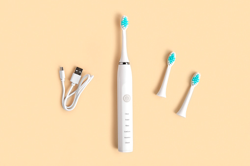 Electric Toothbrush. Top View, Flat Lay, Copy Space. Dental Care Supplies on Beige Pastel Studio Background. Oral Hygiene, Gum Health, Healthy Teeth. Modern Dental Ultrasonic Vibration Tooth Brush. sonic smart technology. bleaching