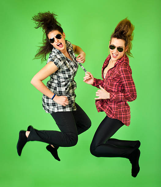 Teenagers with sunglasses jumping stock photo