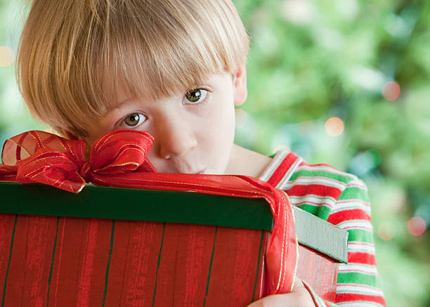 bonito rapaz com uma prenda de natal - christmas child little boys peeking imagens e fotografias de stock
