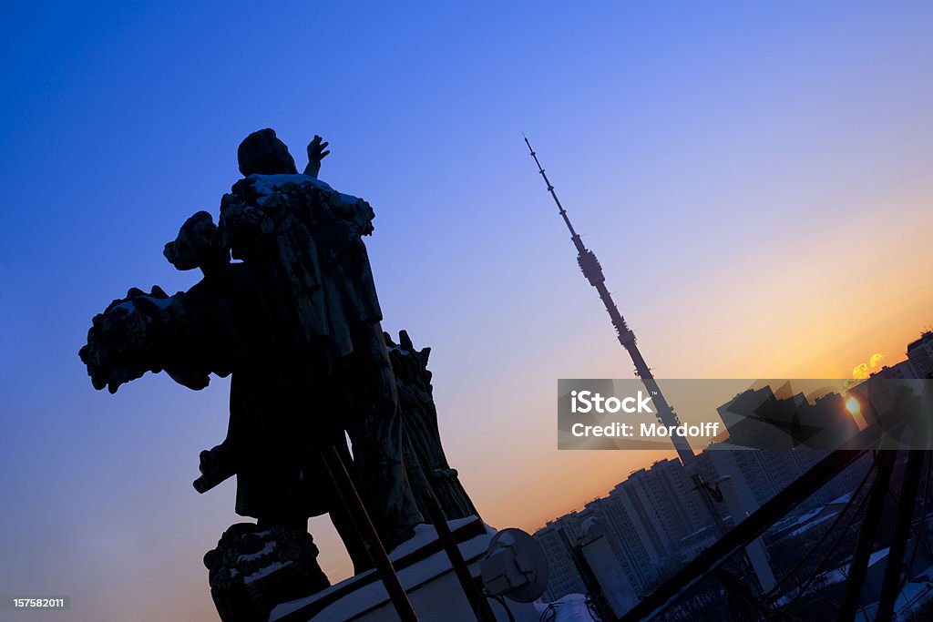 Sunset of empire. Statues on VDNKH pavilion reaching for sun View from Main pavilion of All-Russian Exhibition Centre. Ostankino Tower is on horizon Architecture Stock Photo