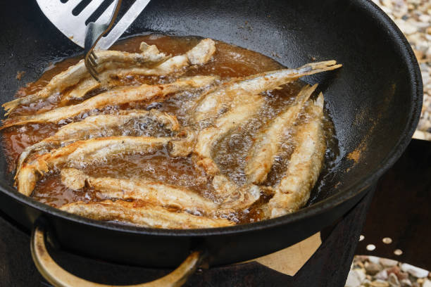 istock Small crispy fish are fried in oil. 1575821041