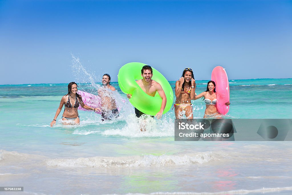 Grupo de jovens jogando água na ilha tropical praia turquesa - Foto de stock de Adolescente royalty-free