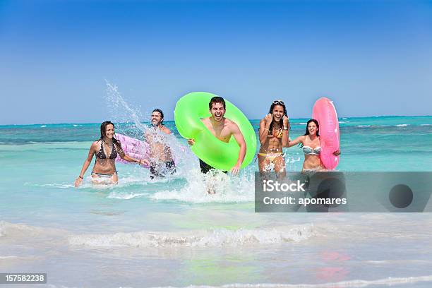 Foto de Grupo De Jovens Jogando Água Na Ilha Tropical Praia Turquesa e mais fotos de stock de Adolescente