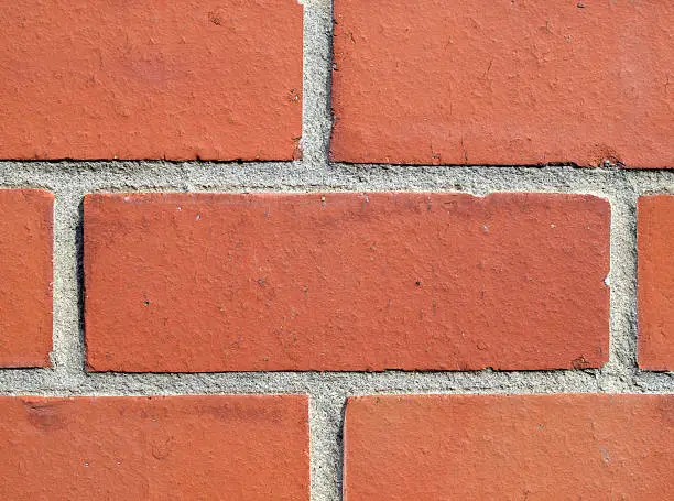 Photo of Close-up of a red brick wall with emphasis on one brick
