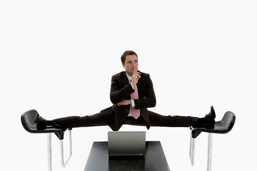 Manager doing the splits between two chairs.