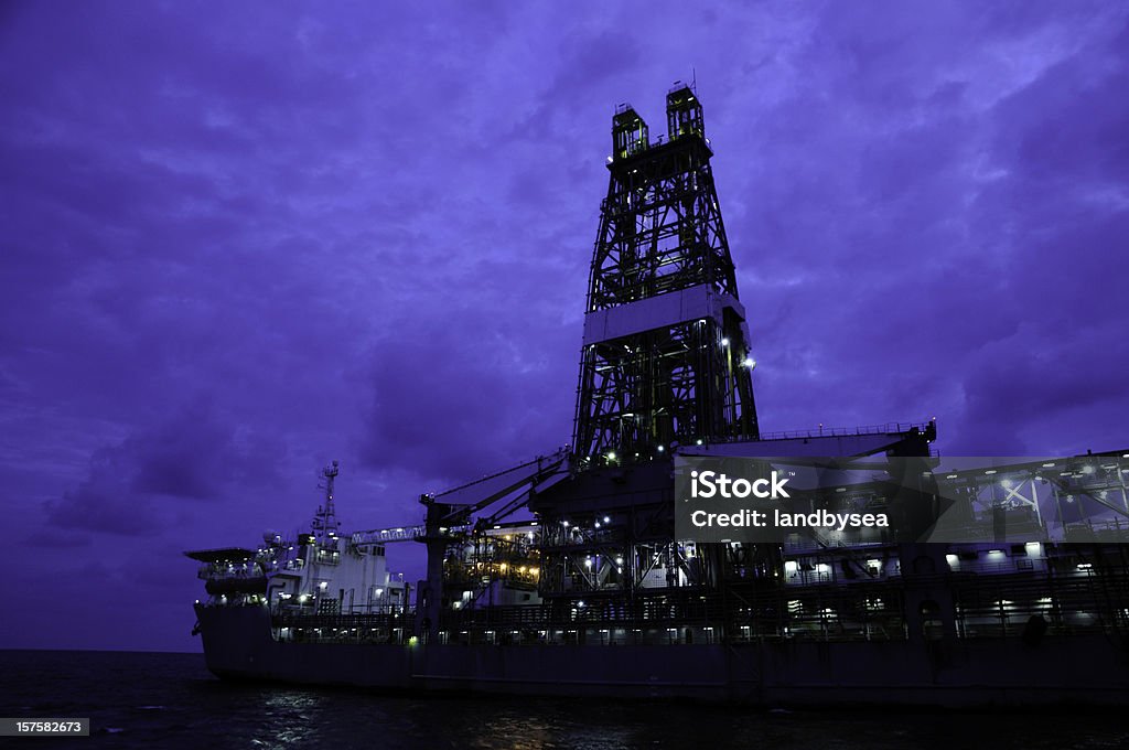 Drill ship at twilight A drill ship type  oil rig photographed at early dawn with lights on. Crude Oil Stock Photo