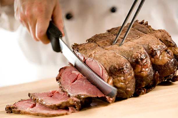 Chef carving perfectly cooked prime rib roast beef  carving set stock pictures, royalty-free photos & images