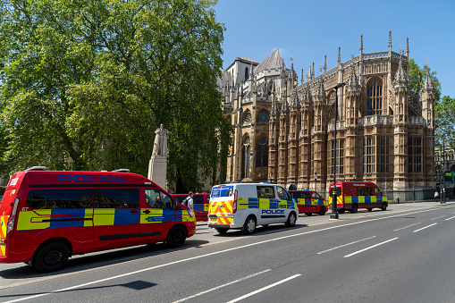 The rear of Westminster Abbey with Police vehicles to protect the House of Parliament opposite. London, England.