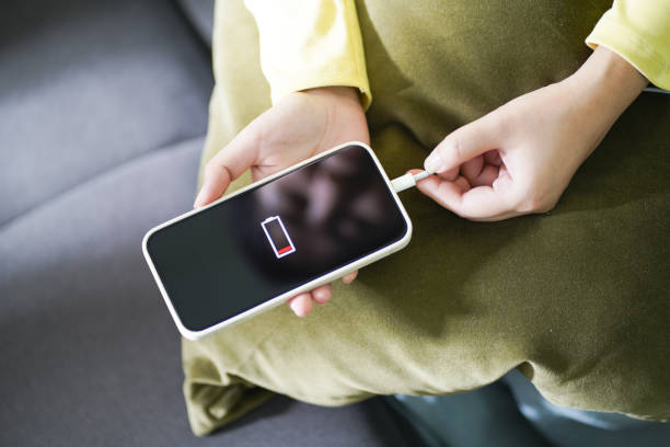 istock Woman hands Charging mobile phone battery with low battery. plugging a charger in a smart phone Â with energy bank powerbank power charger Modern lifestyle energy technology concept. 1575832668
