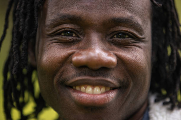 Close Up Portrait of an Expressive Authentic African Kid Laughing and Looking at the Camera Blurry Background. Happy Energetic Black Boy Full of Life Smiling Happily and Enjoying Life and Childhood