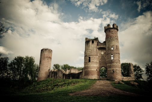 The photo was postprocessed by increasing the contrast, desaturating the colors, adding a sepia cast. Finally a strong vignetting was added.Ruined tower in dark mood sky. The name of the castle is Ch