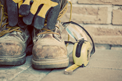 Construction boots and gloves. Desaturated grunge look applied.