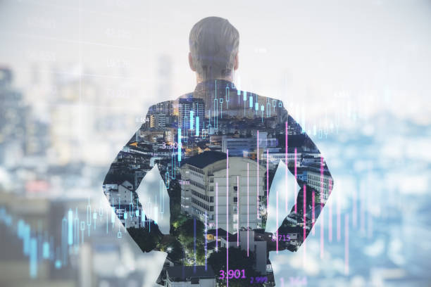 istock Back view of successful young man silhouette using forex chart hologram on blurry city background with mock up city view. Future and financial freedom concept. Double exposure. 1575835993