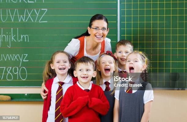 School Kids Posing With Their Teacher Portrait Stock Photo - Download Image Now - Green Color, School Uniform, 6-7 Years