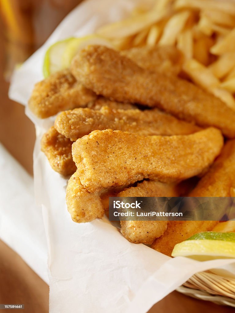 Tiras de pollo con papas fritas en una cesta - Foto de stock de Fritura libre de derechos