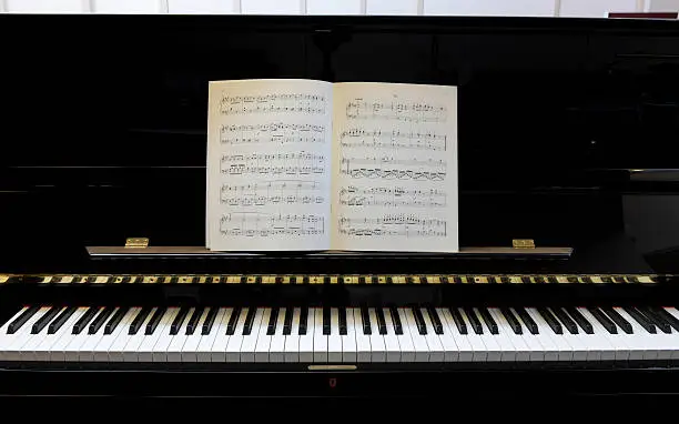 Photo of sheet music on black lacquered piano XXXL image