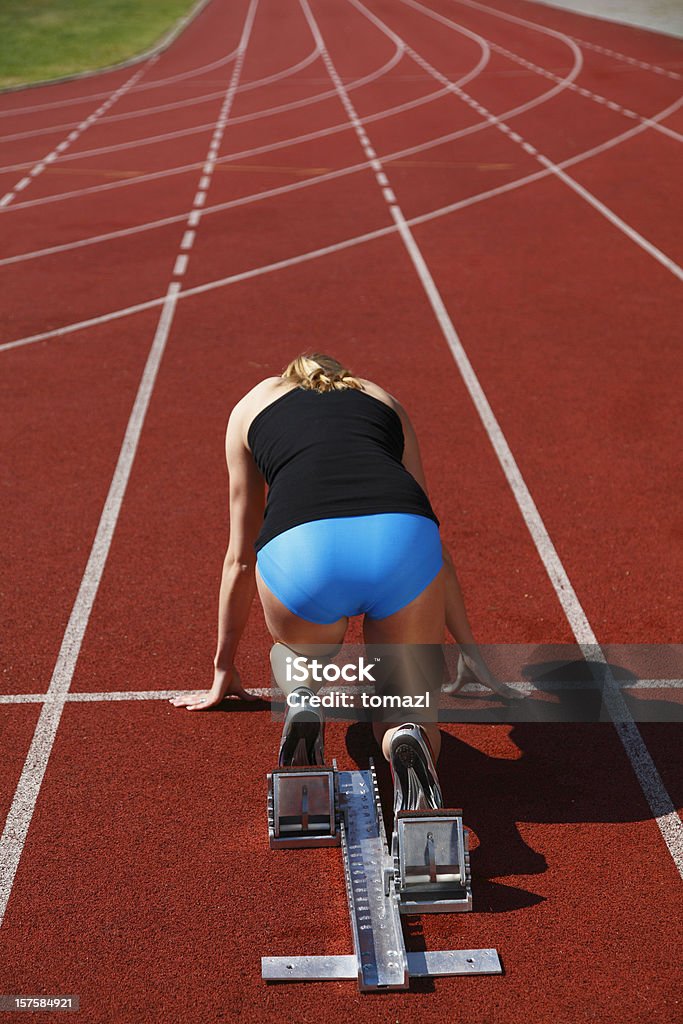 Donna corridore in blocchi di partenza - Foto stock royalty-free di 20-24 anni