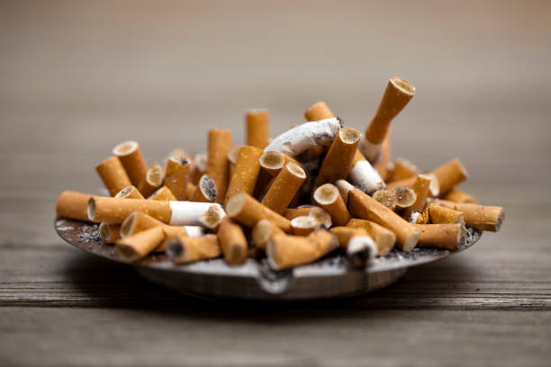 Ashtray bulging with cigarettes stock photo