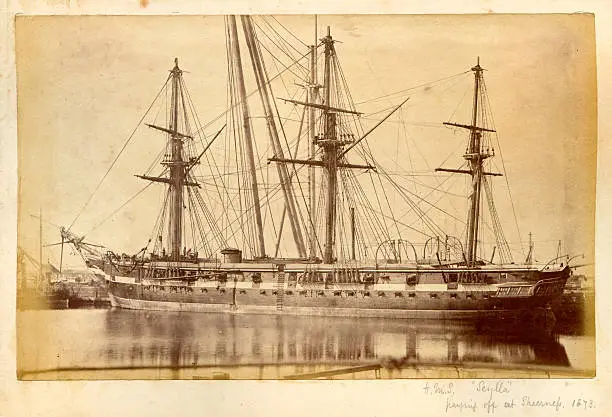 Vintage photograph of the Royal Navy warship HMS Scylla taken at Sheerness Dockyard, Kent in 1873.   Scylla was a 16 guns, 400-horse power wooden screw corvette launched in 1856 and paid off in 1873. She served in the Mediterranean and the Pacific Station.