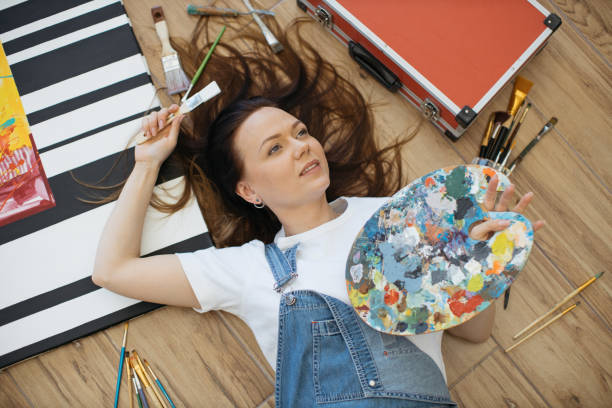 istock Designer dreaming on floor with paintbrush and palette 1575853353