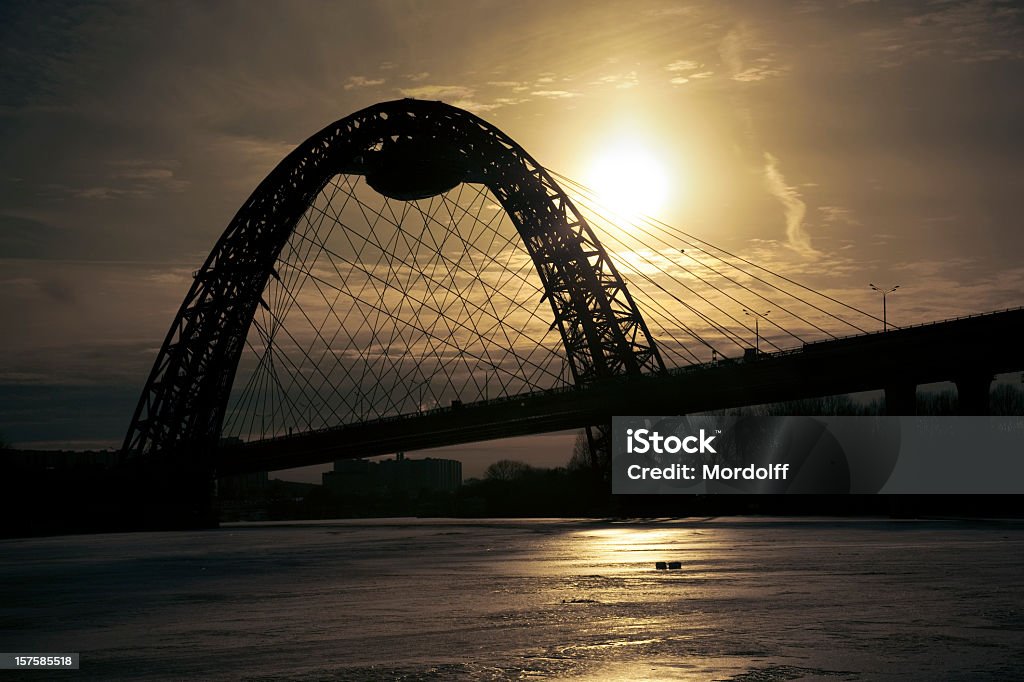 Silhoette na Most nad zamrożonych river o zachodzie słońca - Zbiór zdjęć royalty-free (Architektura)
