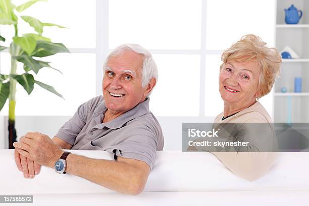 Photo libre de droit de Souriant Couple Âgé Assis Sur Le Canapé Puis Tournez La Caméra banque d'images et plus d'images libres de droit de Adulte