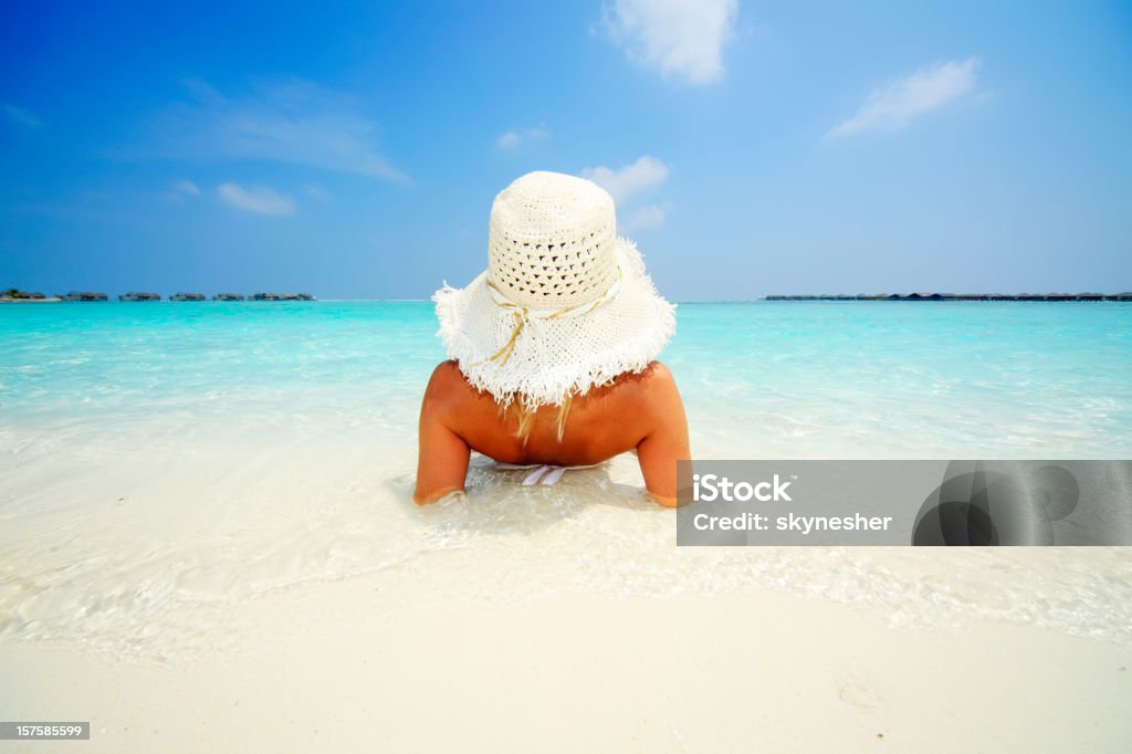 Young attractive woman acostado en la costa del mar tropical. - Foto de stock de Acostado libre de derechos